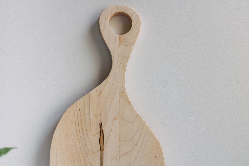 Close up image of the handle and unique organic shape of the cutting board. 