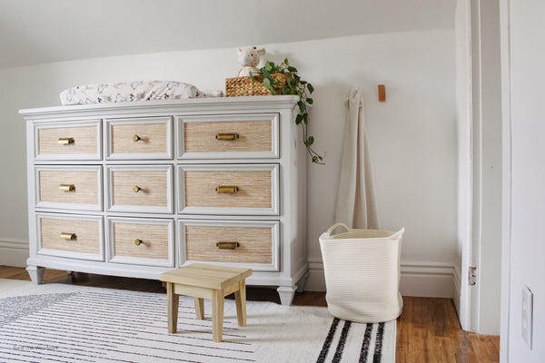 Maple step stool styled in front of a dresser in a nursery.