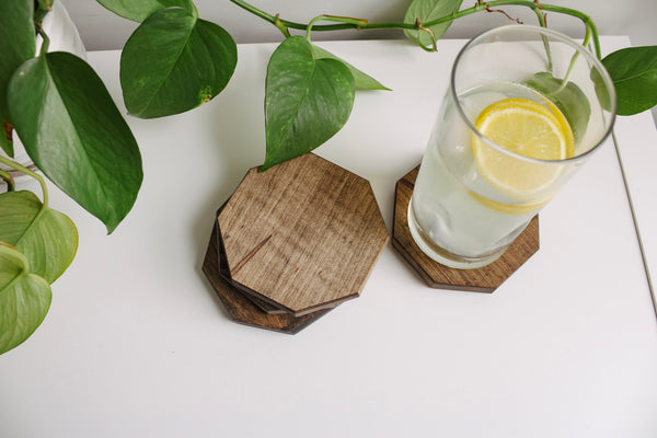 Set of four octagon wood coasters, one of the coasters has a glass of lemonade sitting on it.