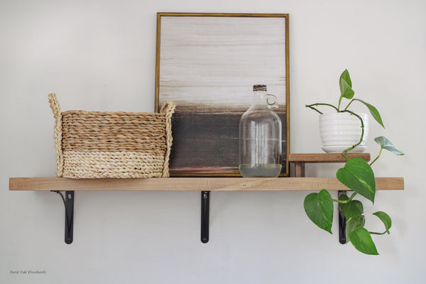 Wooden tray riser stand styled on an open shelf. With a plant set on the wooden stand